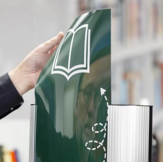 Une main décolle le panneau d'habillage imprimé d'une borne LibDeco